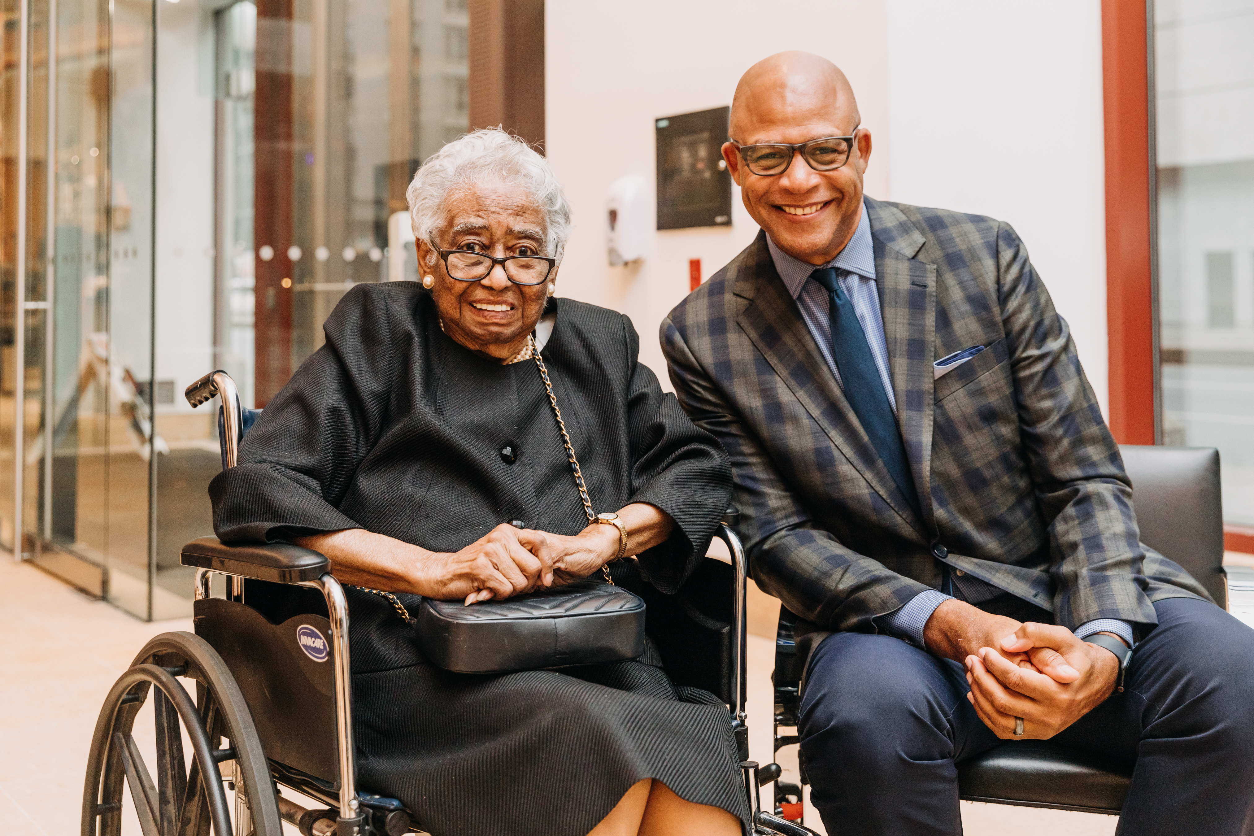 Eric with an elderly woman, smiling.