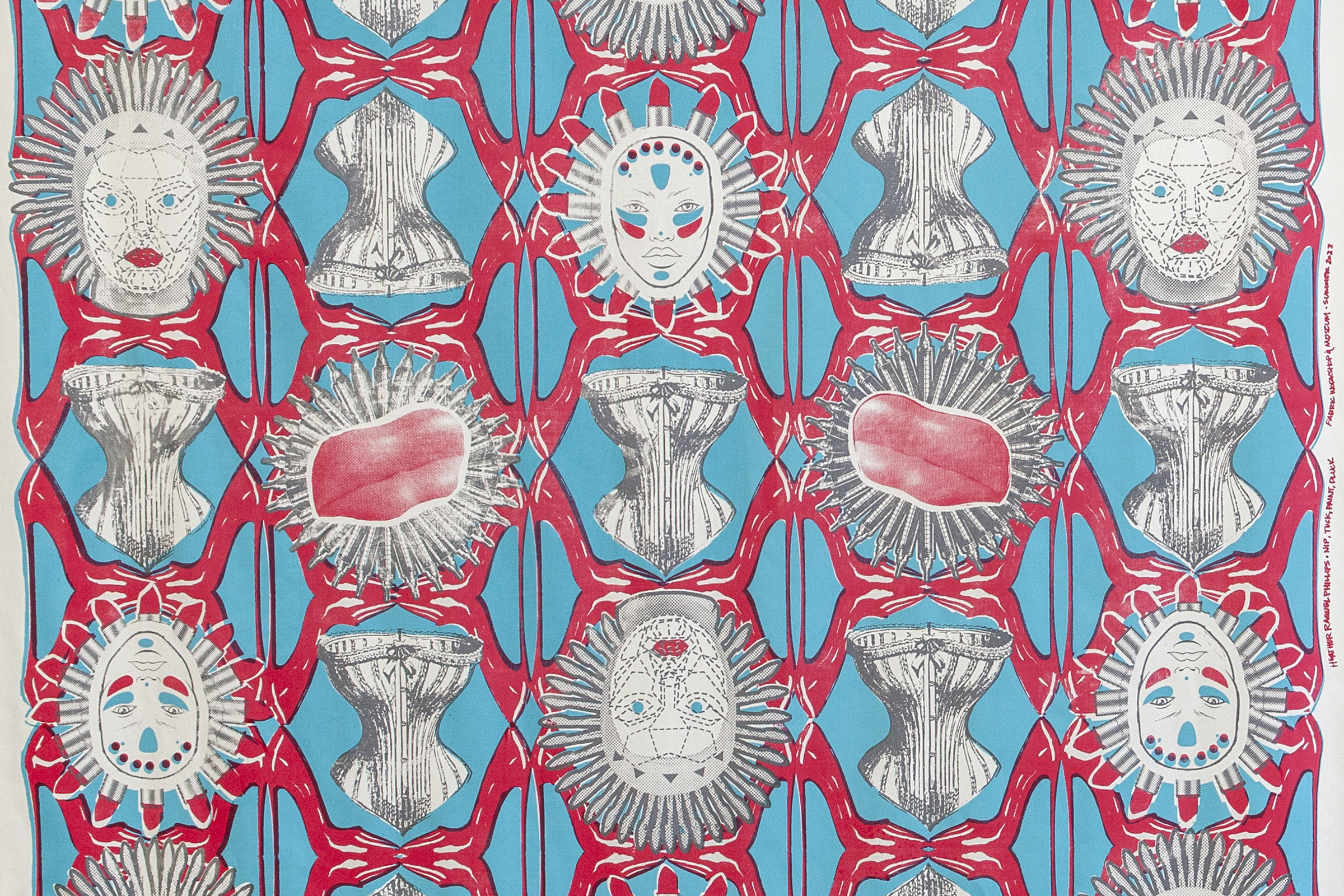 A vibrant repeating textile pattern in red, cyan, and off-white shows interlocking geometric motifs with stylized human faces featuring red lips and spiky halo-like hair, gray corset- or armor-like forms, and circular sunburst shapes with pink, organic-looking centers.