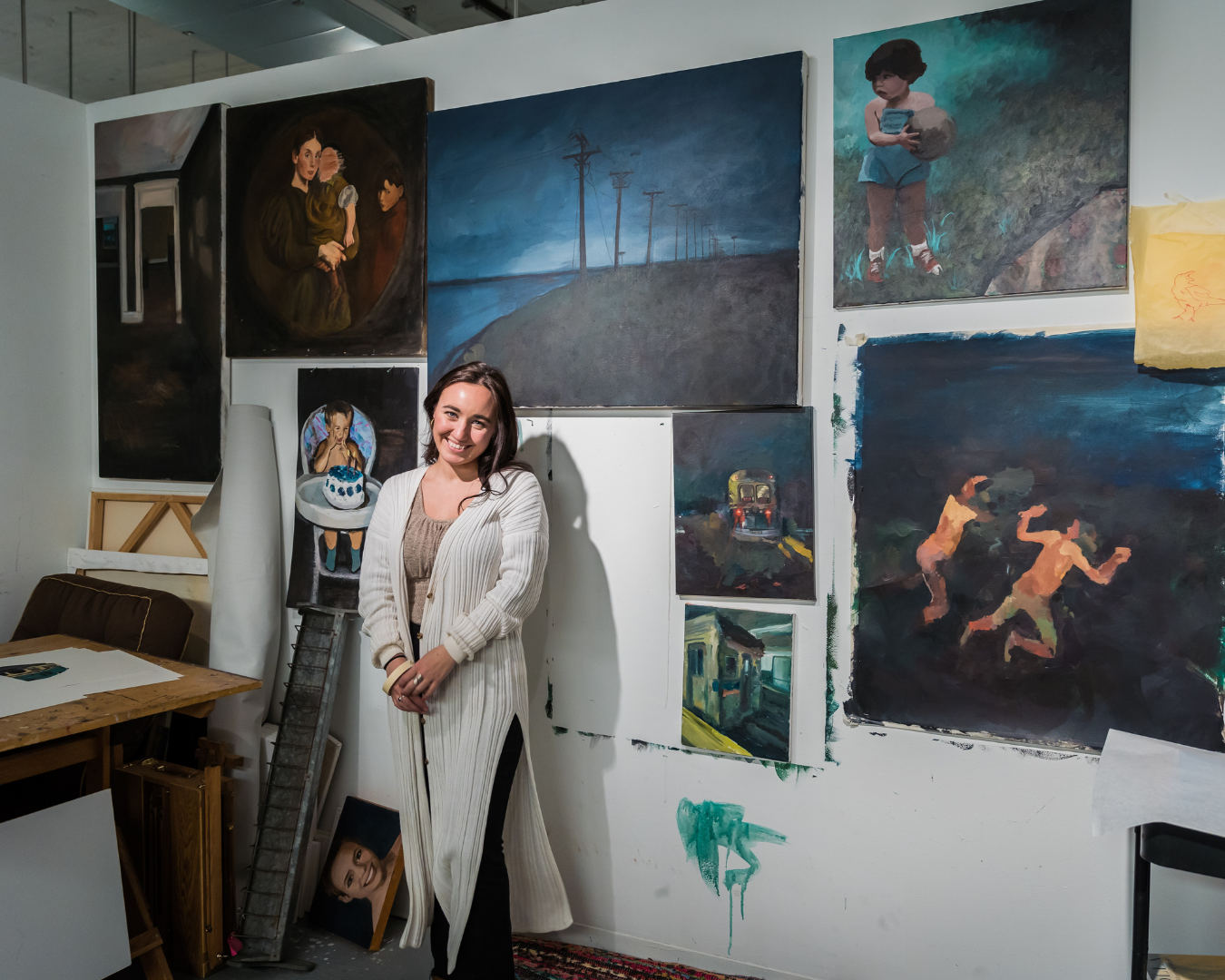 Madison Greiner in her studio surrounded by her oil paintings.