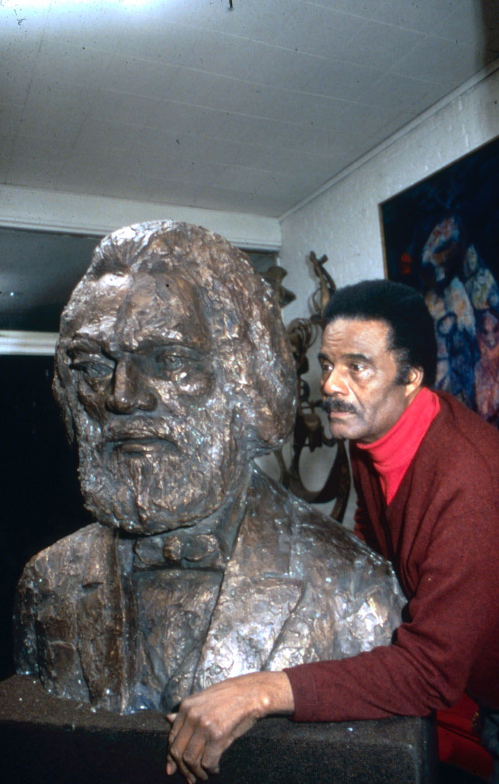 John Rhoden poses with bust of Frederick Douglass