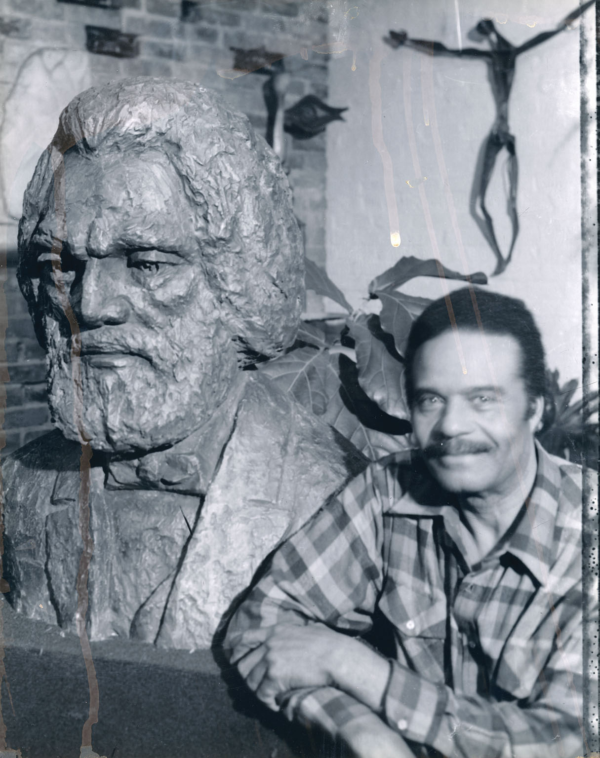 John Rhoden poses with bust of Frederick Douglass