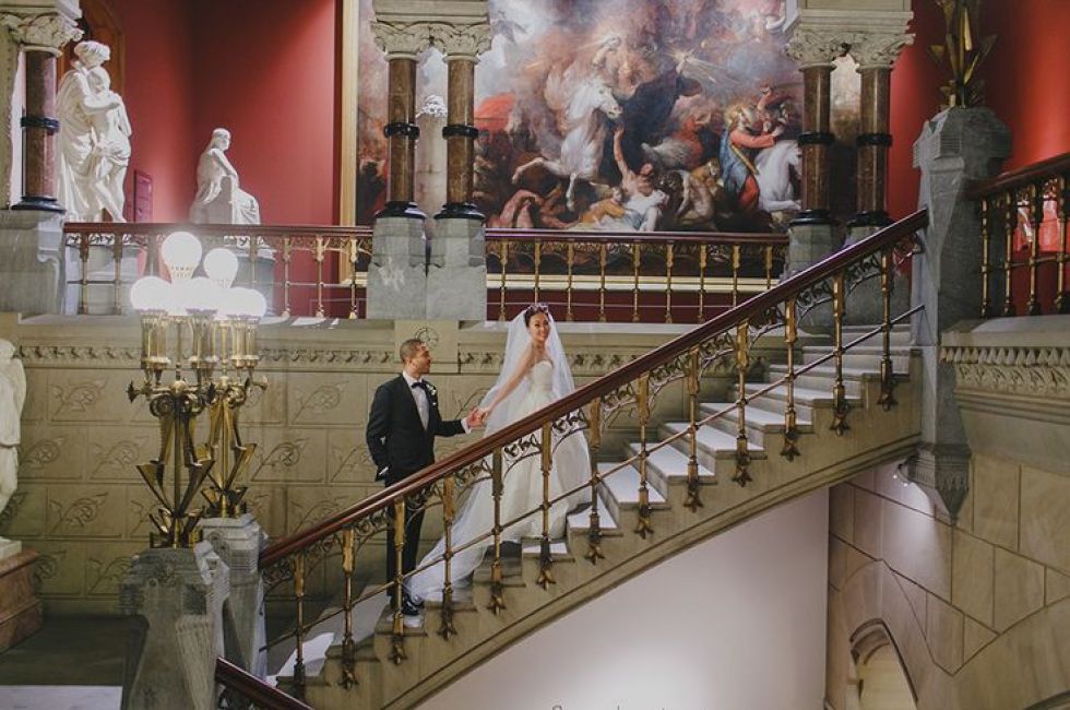 Bride and groom on the staircase of the Historic Landmark Building.