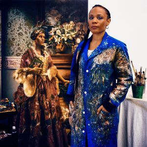 Image of the artist with her paintings, photo from Vogue magazine (Photographed by Anton Corbijn, Vogue, October 2018 / Painting: Elizabeth Colomba. Winter, 2017. Oil)