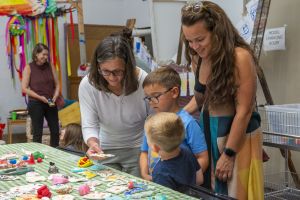 parents and children looking at art work on a table