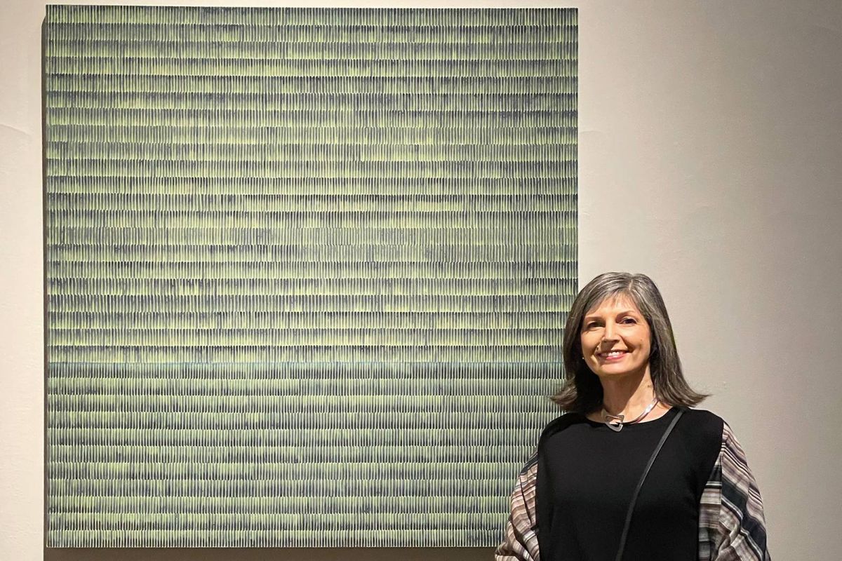Anna Bogatin Ott standing in front of her painting 'Everglades.'