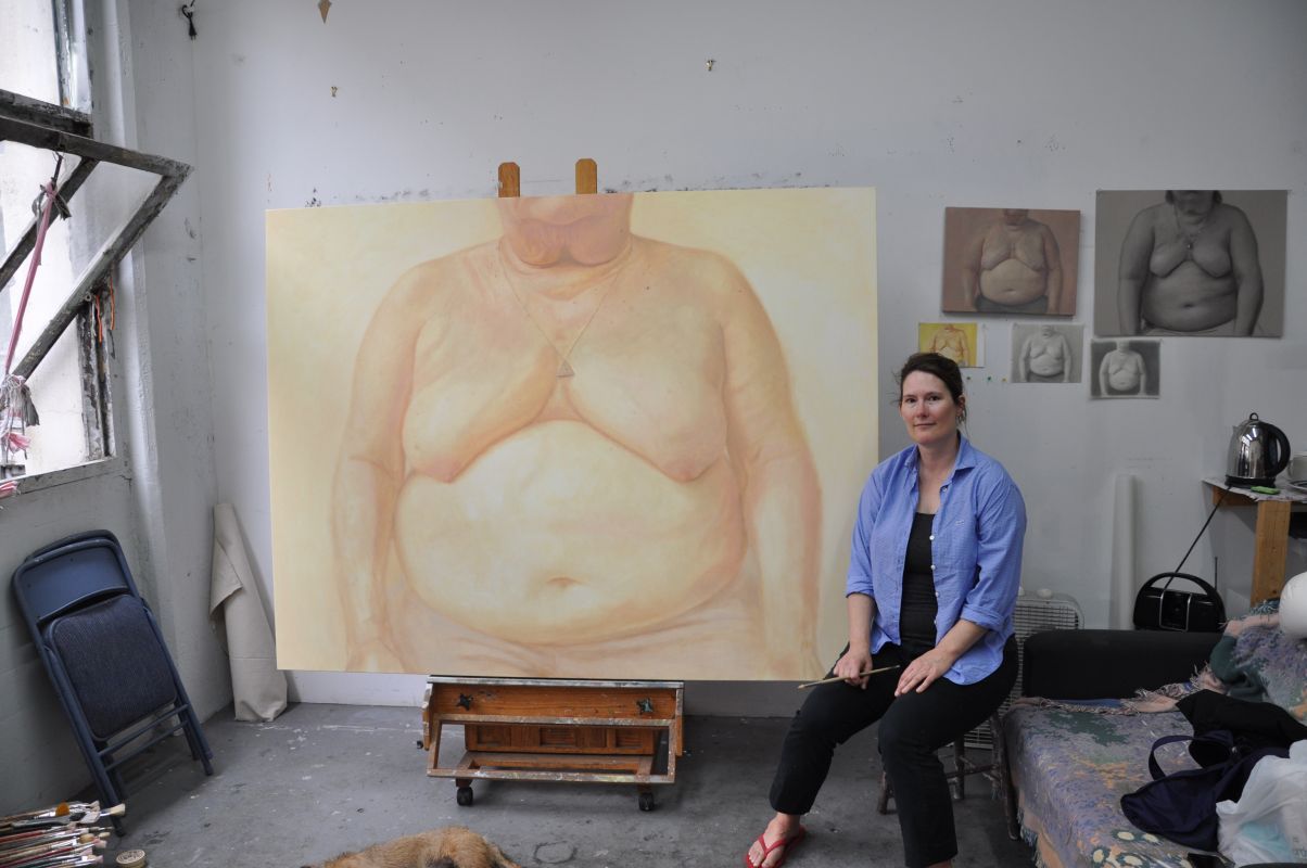 Clarity Haynes in her studio with a painting.