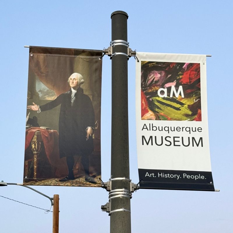 Street pole banners featuring Peale's George Washington portrait and a sign for the Albuquerque Museum.