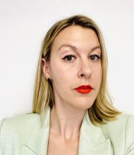 Bio photo of Ali Printz, a light-skinned woman with dark blond straight hair that falls below the shoulders, wearing red lip stick and a light green blouse.
