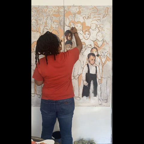 Athena Scott with back turned works on large painting of figures