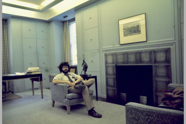 Tony Rosati sitting in a chair in an open room with a fireplace